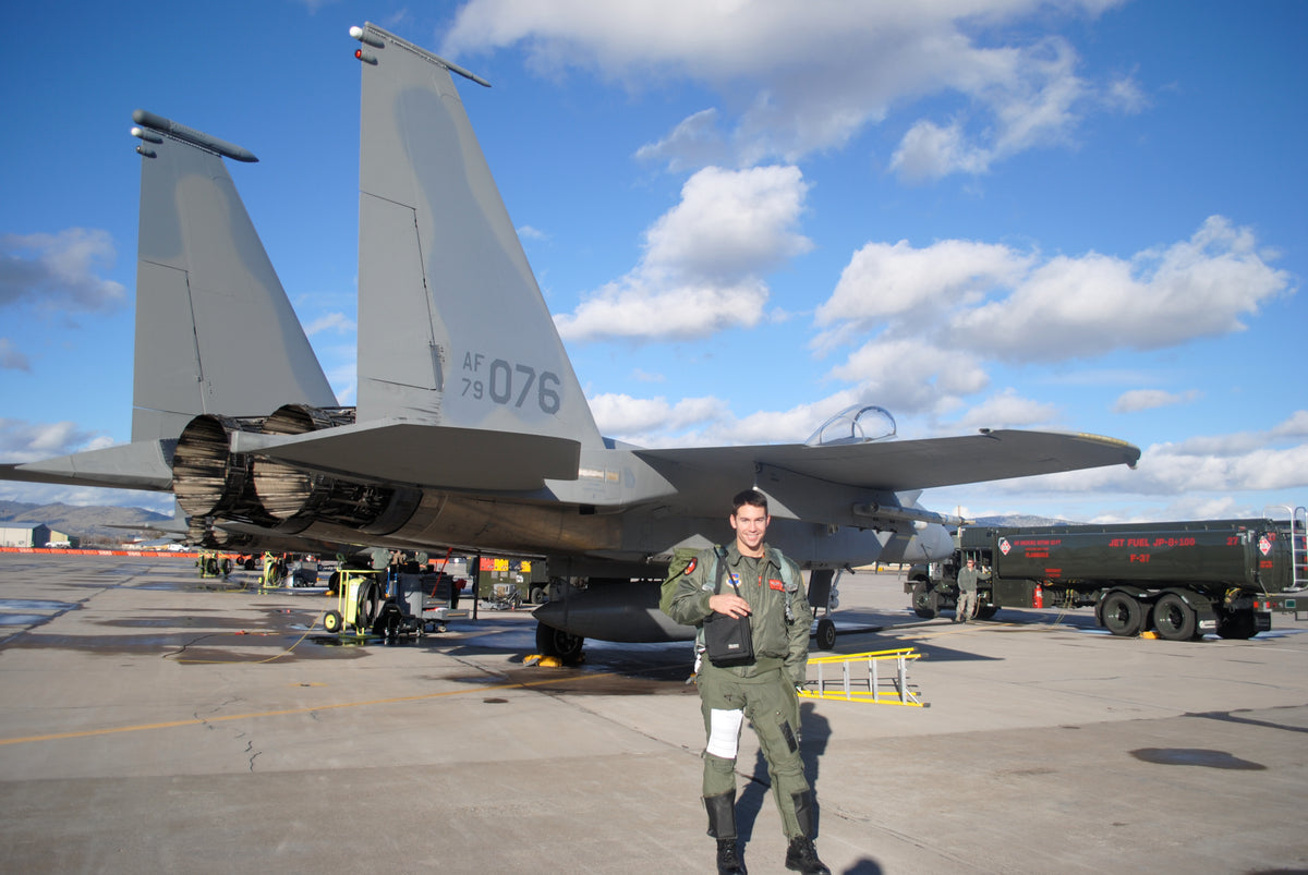 GTG founder Joshua Cabo Gunderson standing in front of an F-15 fighter aircraft
